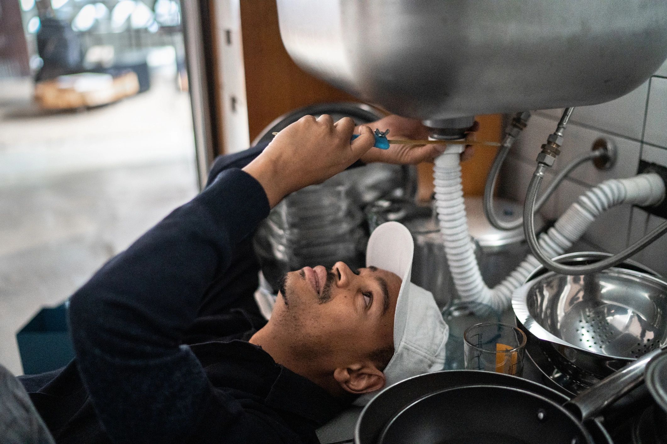 Plumber working beneath a kitchen sink